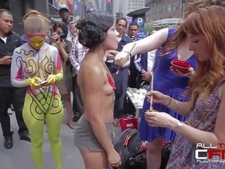 Group of naked people get painted in front of publ